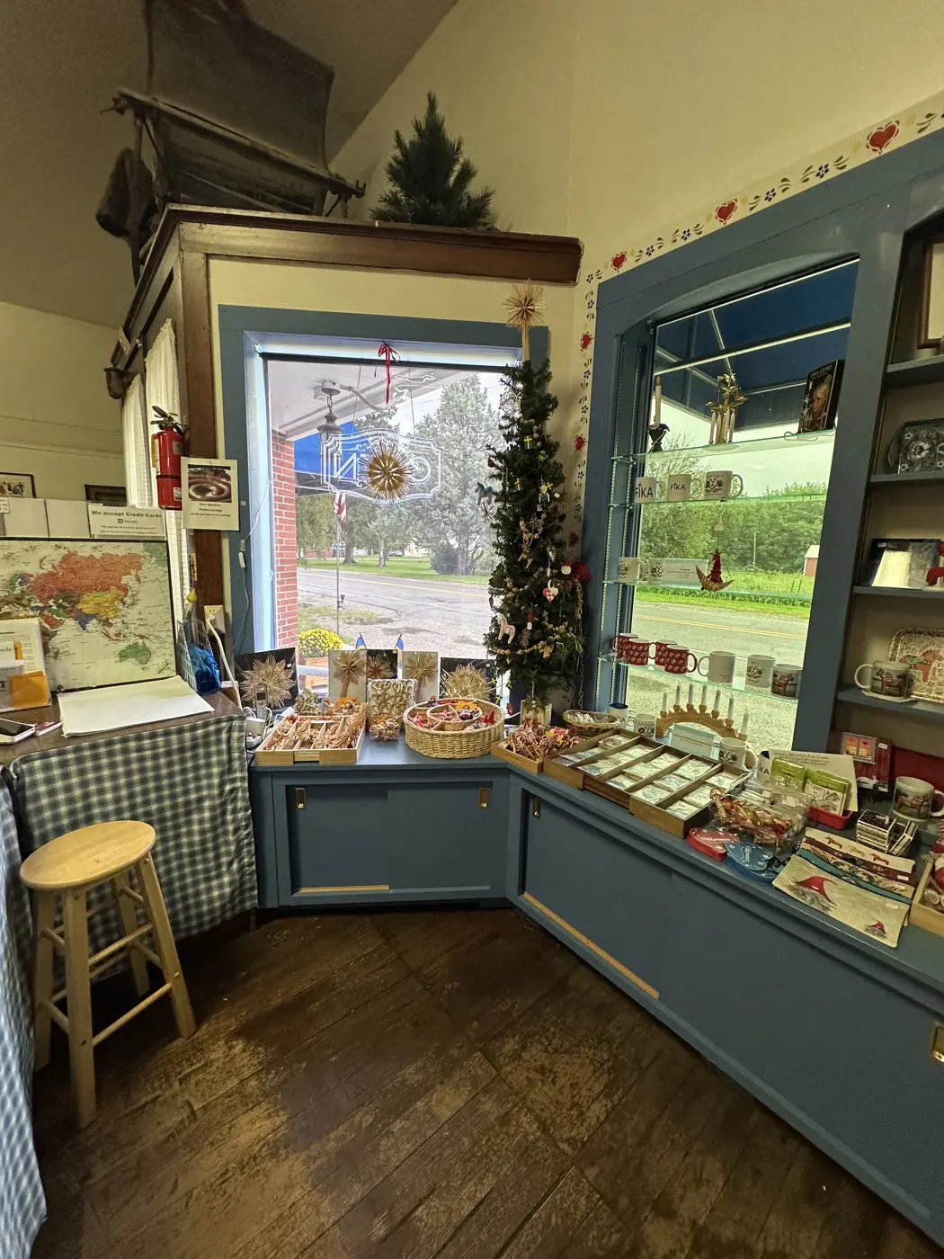 Inside the museum's Scandinavian gift shop: a little Christmas tree, straw ornaments, baskets of treats and shelves of mugs by the front window.