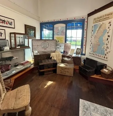 The From Sweden to America exhibit with steamer trunks, baskets and a large map of Sweden.