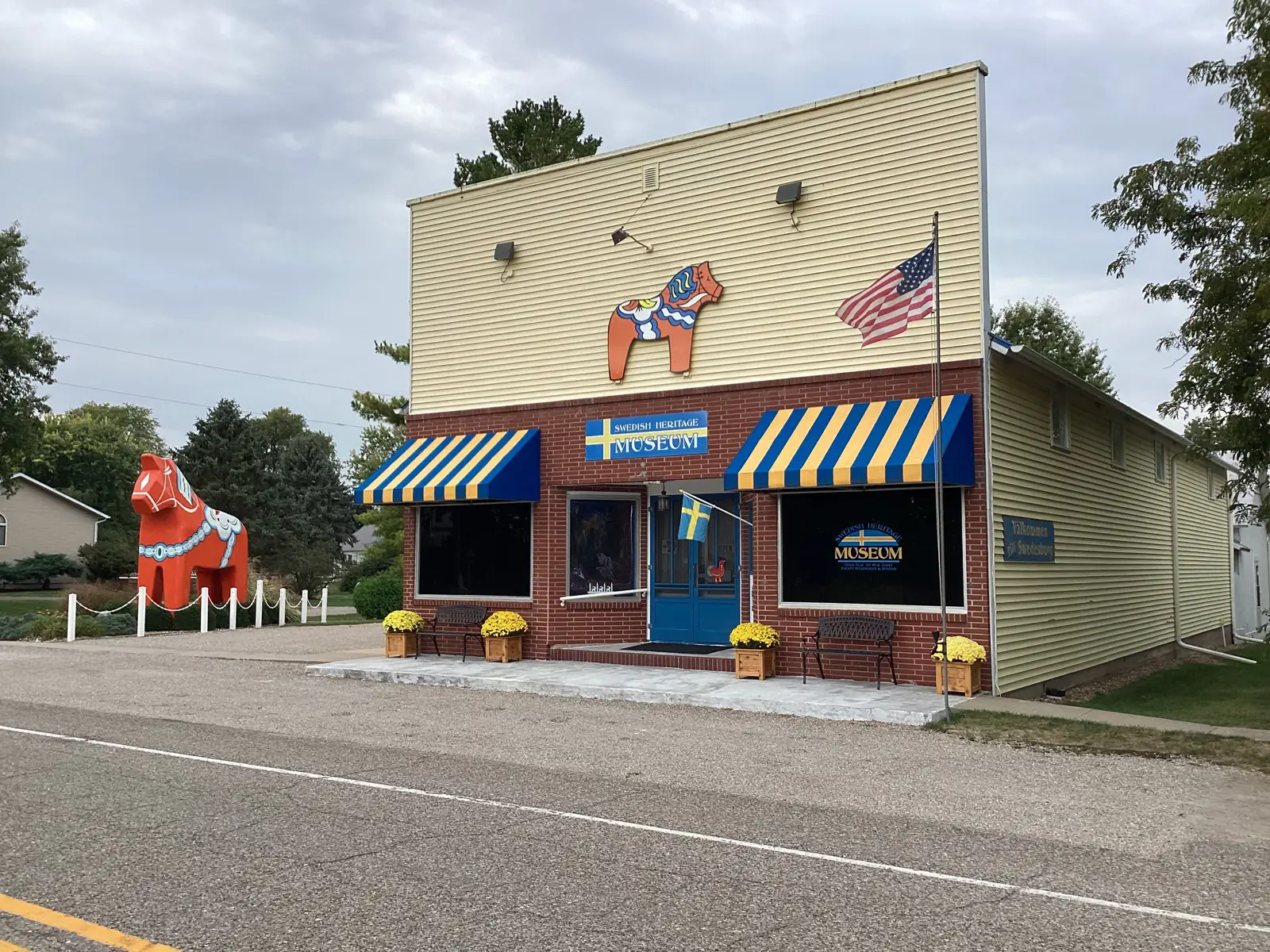 The Swedish American Museum storefront today, with blue and yellow awnings and the giant red Dala horse Ole beside it.